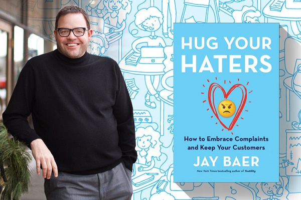 A Book About Hug Your Haters By Jay Baer On Display With An Image Of The Author.