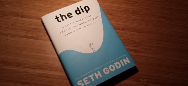 The Dip - A Book By Seth Godin Placed On The Wooden Table.