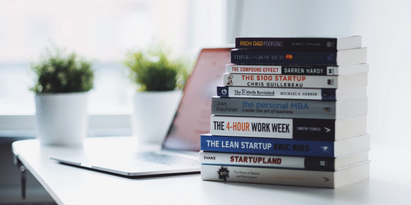 A Pile Of Books About Entrepreneurship Skills. Placed On The White Table.