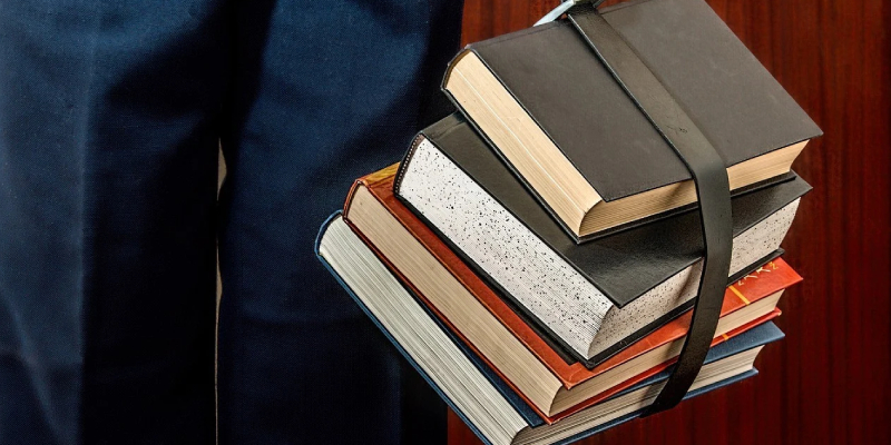 A Pile of Books Which Was Tied Up By A Black Belt.