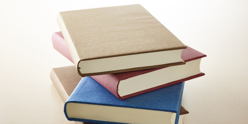 A Pile Of Books Having Different Colored Cover Placed On The White Background.