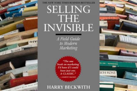 A Shelf Full of Marketing Books Infront Of A Book Selling The Invisible By Harry Beckwith.