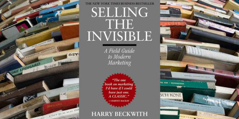 A Shelf Full of Marketing Books Infront Of A Book Selling The Invisible By Harry Beckwith.