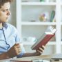 A Business Woman Reading A Book About Best Marketer.