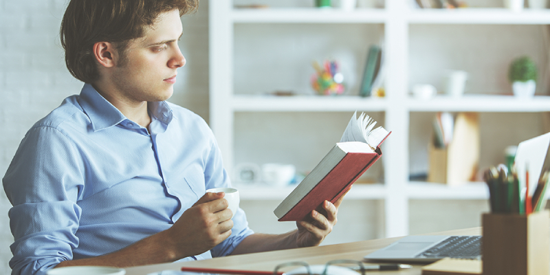 A Business Woman Reading A Book About Best Marketer.